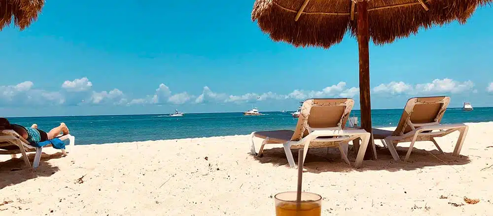 Cozumel beach with sun chairs and boats