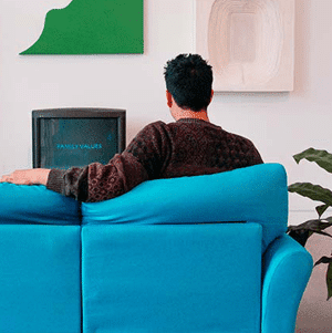 man watching tv sitting on blue sofa